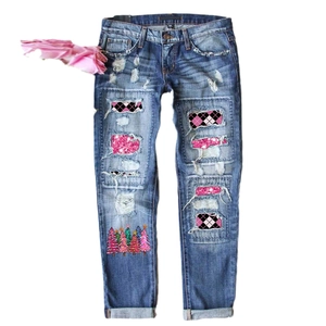Women's light blue ripped jeans featuring pink sequin patches and Christmas tree prints