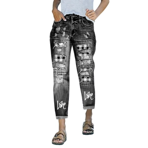 Detail of distressed grey jeans with plaid patches and white Love script printing