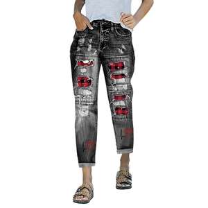 Detail of distressed black jeans with red buffalo plaid patches and heart print