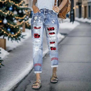 Women's light blue distressed jeans with Chicago print and red plaid patches in snow