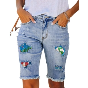 Women's light blue distressed mid-rise denim shorts with colorful holiday printed patches