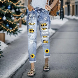 Women's light blue distressed jeans with sunflower prints and plaid patch details