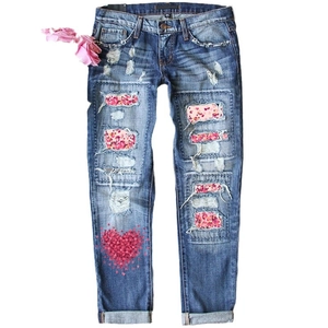 Jean femme avec déchirures, patchs en forme de cœur et imprimé rose