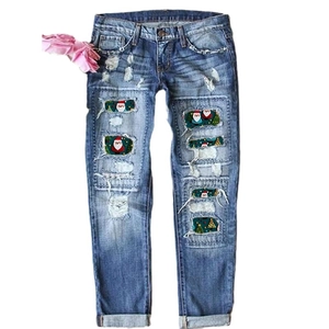 Mid-blue ripped jeans with festive Christmas prints inside holes and flower detail