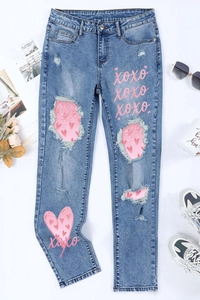 Women's light blue distressed jeans with pink sequin heart patterns and XOXO prints