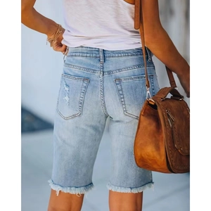Women's light blue denim Bermuda shorts with distressed holes and frayed hems seen from back