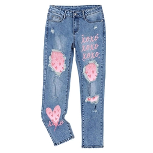 Distressed blue denim jeans with pink heart patterns and XOXO print for women