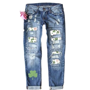 Blue distressed straight leg jeans with clover print patches and ripped details