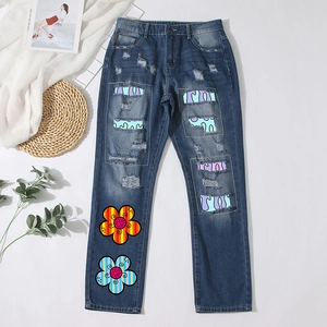 Distressed dark blue straight leg jeans with colorful floral embroidery and patchwork details