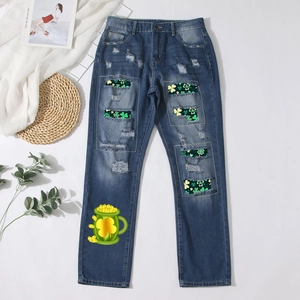 Jeans bleu délavé avec trous usés et écussons trèfles verts pour la Saint-Patrick