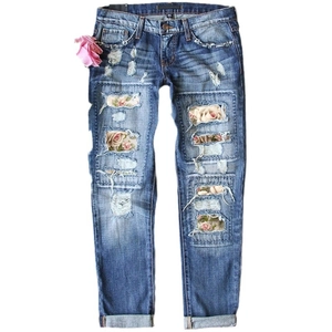 Women's light blue distressed jeans with floral patchwork and stylish ripped details