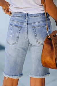 Women's light blue distressed denim bermuda shorts with frayed hems and ripped details