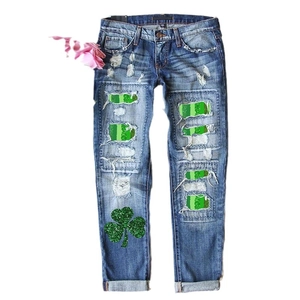 Women's straight blue denim jeans with St. Patrick's clover glitter and green patches