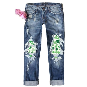 Distressed dark blue straight leg jeans with St. Patrick's Day clover print patches
