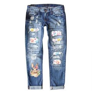 Women's mid-waist ripped blue jeans with Easter bunny print and colorful egg patches
