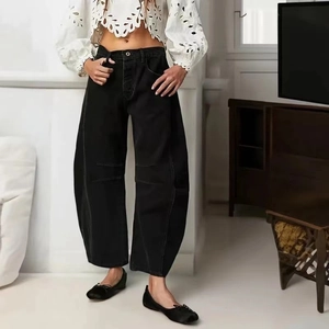 Detail of high-waist black wide-leg denim pants with horizontal knee pleat design