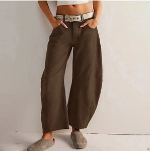 Detailed view of brown wide-leg trousers featuring unique curved seams and a high-waist fit