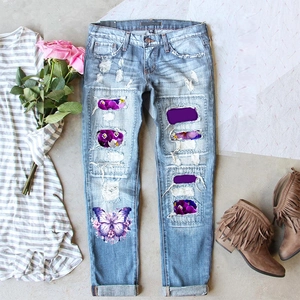 Women's light blue distressed straight jeans with purple floral and butterfly prints