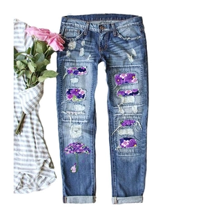 Women's straight blue washed jeans featuring ripped holes and purple floral umbrella print