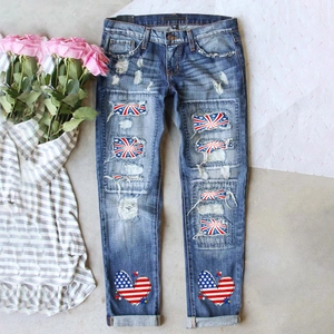 Détail de jeans déchirés avec écussons drapeau américain et cœurs sur les chevilles