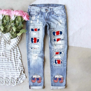 Détail d'un jean bleu clair déchiré avec doublure motif drapeau et imprimé de mugs de bière