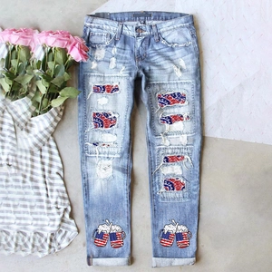 Détail de jean déchiré avec écussons drapeau américain et imprimé bière sur denim bleu