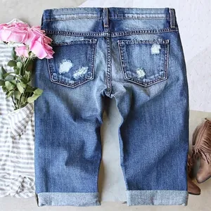 Distressed blue mid-waist straight denim shorts with ripped details and cuffed hem