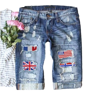 Distressed blue denim shorts with national flag patches and stylish rolled cuffs