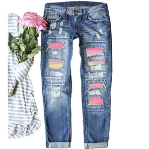 Women's straight jeans in washed blue with leopard distressed holes and pink patches