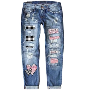 Women's blue washed straight jeans with distressed holes and heart sequin patches