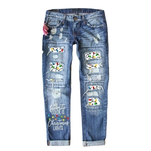 Women's blue Christmas denim jeans with holiday light patches and festive typography