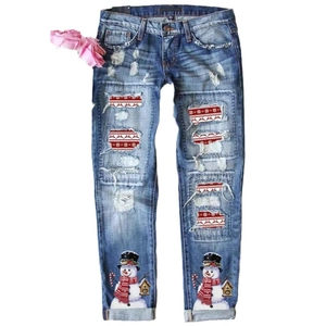 Jean femme bleu clair déchiré avec motifs de Noël festifs, flocons et rennes appliqués