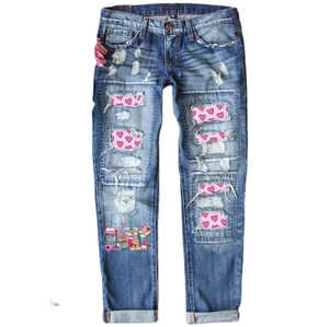Women's mid-waist ripped jeans in mid-blue with heart patches and cartoon BE MINE print