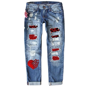 Jean femme bleu clair avec déchirures et patchs cœur en paillettes rouges brodés