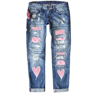 Jean droit bleu pour femme avec déchirures usées, paillettes roses et motifs cœurs