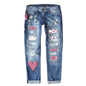Mid-blue ripped straight jeans for women with pink sequined heart patches and distressed details
