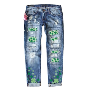Women's blue distressed jeans with St. Patrick's Day green clover print and patchwork