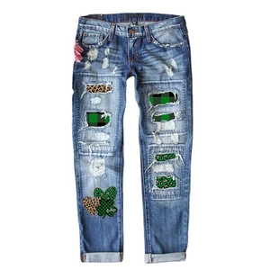 Women's blue distressed jeans with lucky clover patches and leopard print denim