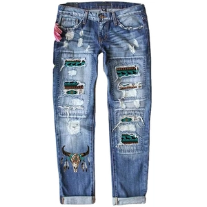 Western style blue distressed straight leg jeans with bull skull print and boho patches