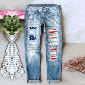 Détail d'un jean vintage déchiré avec écussons drapeau américain et bords effilochés