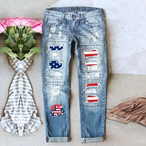 Détail de jean bleu clair avec écussons drapeau américain et finitions denim usé vintage