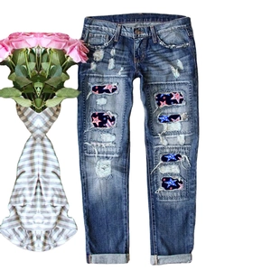 Distressed dark blue straight-leg jeans with American flag star-patterned knee rips