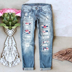 Ripped blue denim jeans with American flag star pattern inserts and cuffed hems