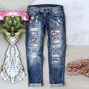 Women's mid-blue wide leg jeans with American flag print patches and ripped details