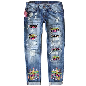 Women's mid-waist ripped blue denim jeans with colorful Cinco de Mayo graphic patches