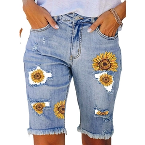 Women's light blue ripped denim shorts with sunflower prints and frayed hems