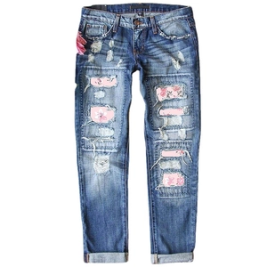 Distressed blue wash straight leg jeans with floral patches and rolled cuffs for women