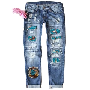 Blue distressed straight leg jeans featuring American western theme embroidery patches