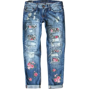Jeans da donna strappati con stampa leopardata e ricami floreali rosa su denim lavato