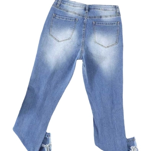 Women's light blue high waist distressed denim jeans with frayed hems and back pockets